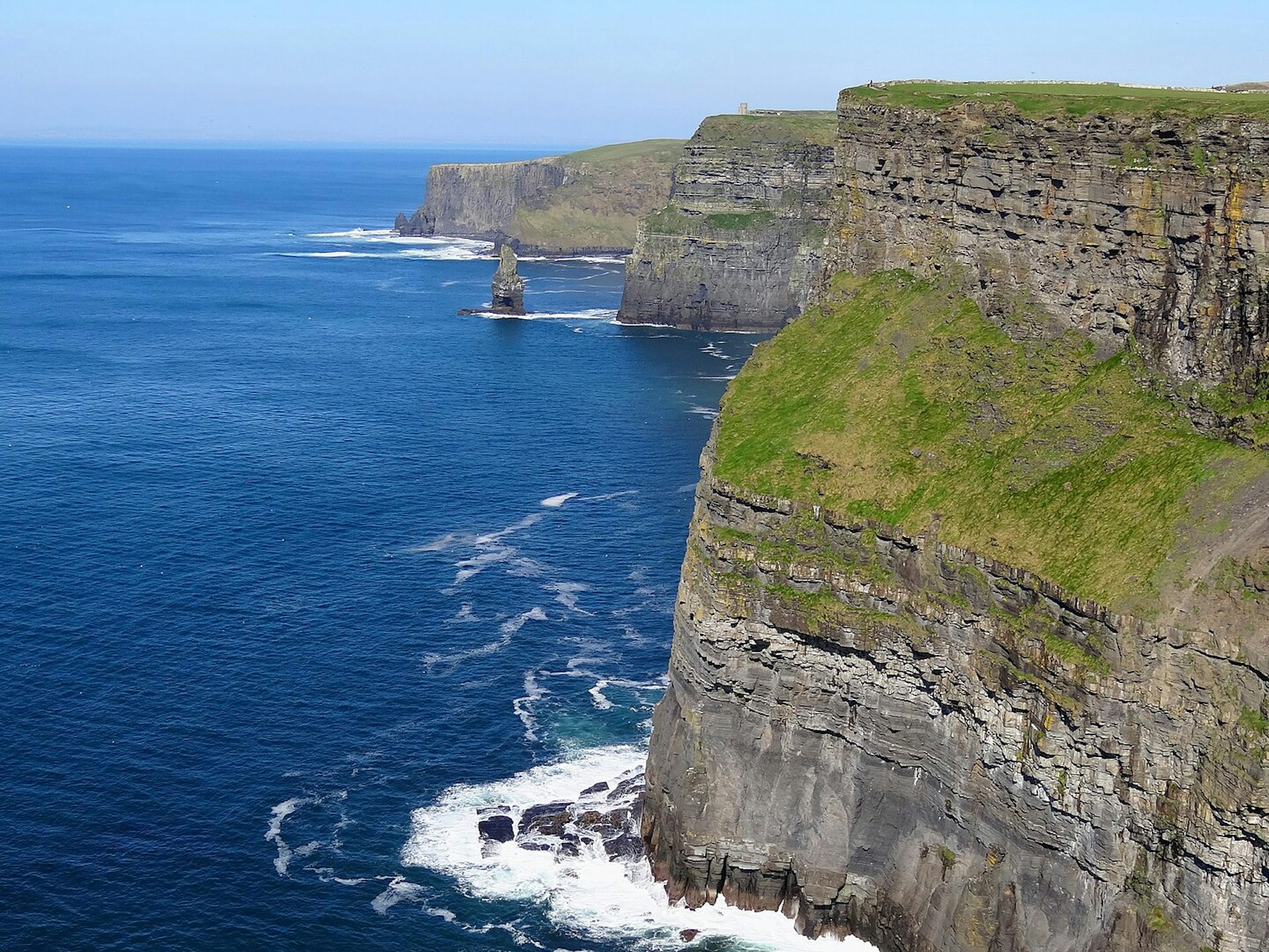 Huge cliffs overlooking a very blue sea.