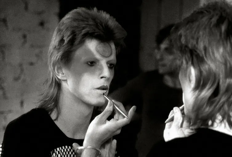 David Bowie se maquiando no espelho