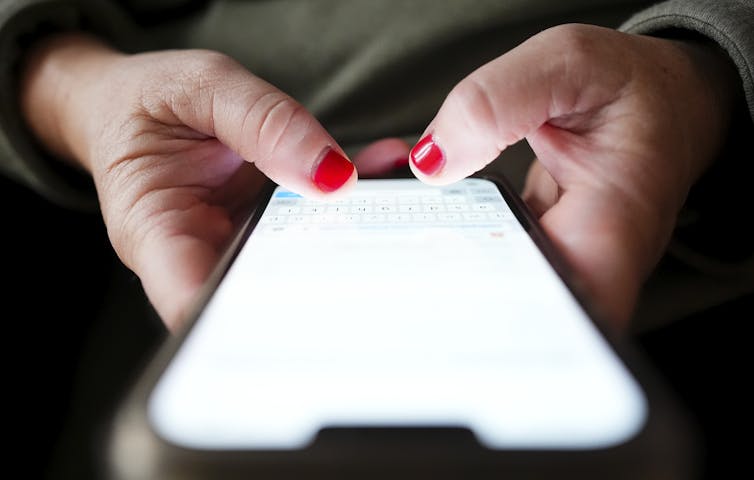 Una persona está escribiendo en un teléfono móvil.