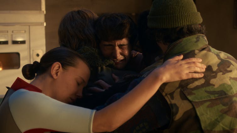 The characters in Stranger Things hug.