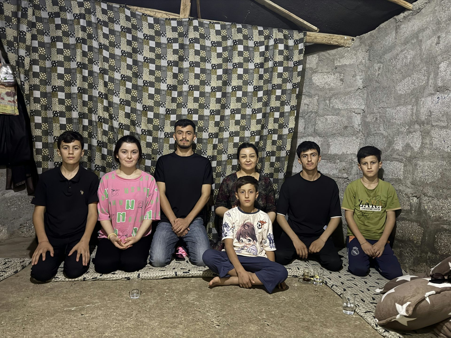 A family sit on the floor and pose for a picture