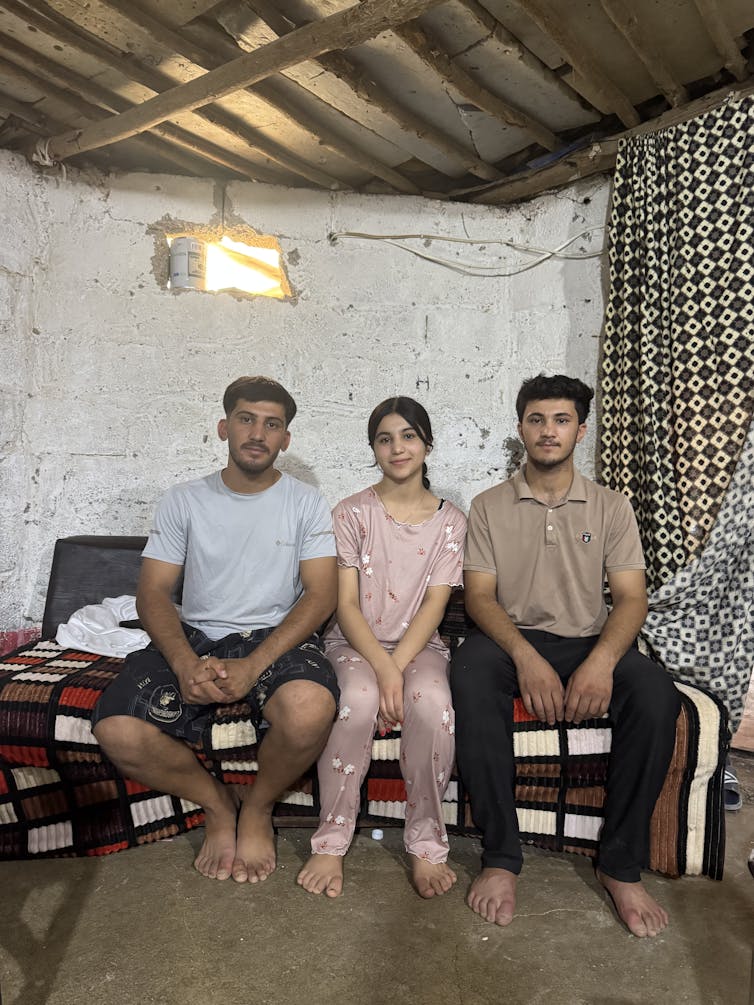 Two boys and girl sit for a photo.