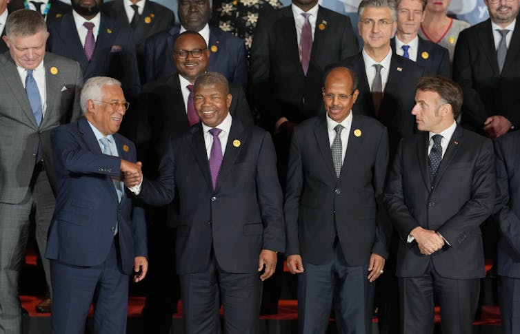 A group of white and black men pose for a photo.