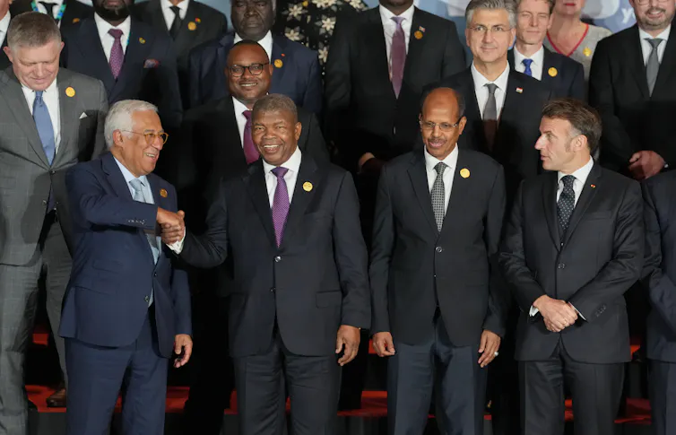A group of white and black men pose for a photo.