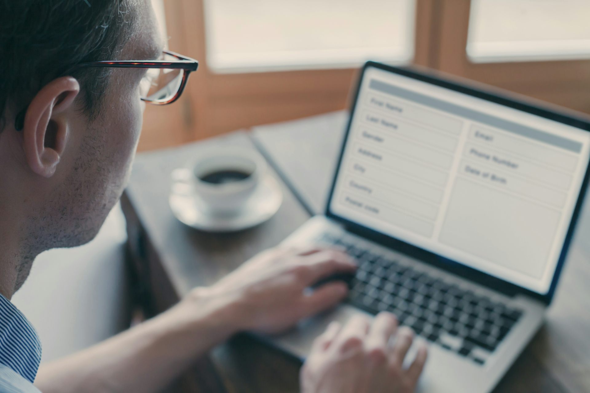 Un home amb ulleres mira la pantalla d'un ordinador portàtil que mostra un formulari.
