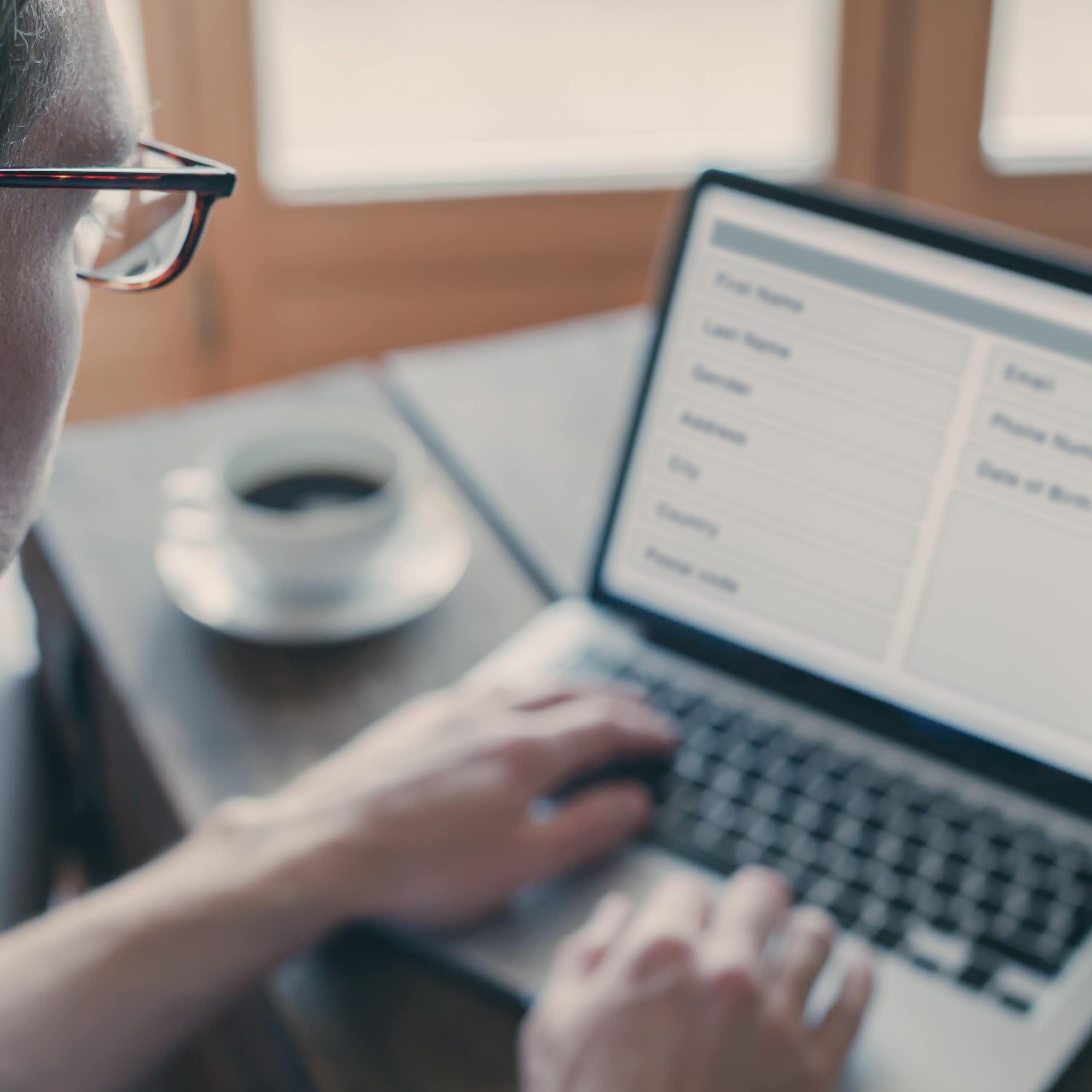 Un home amb ulleres mira la pantalla d'un ordinador portàtil que mostra un formulari.