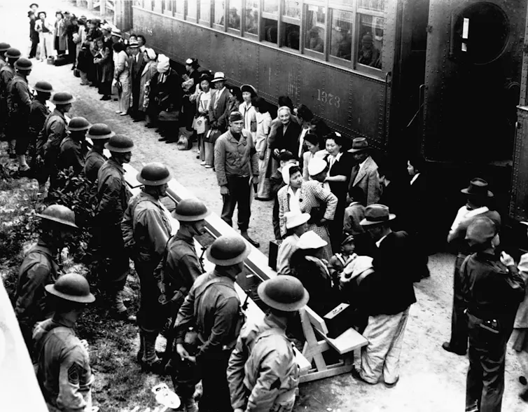 Japanese-Americans arrive at a train station.