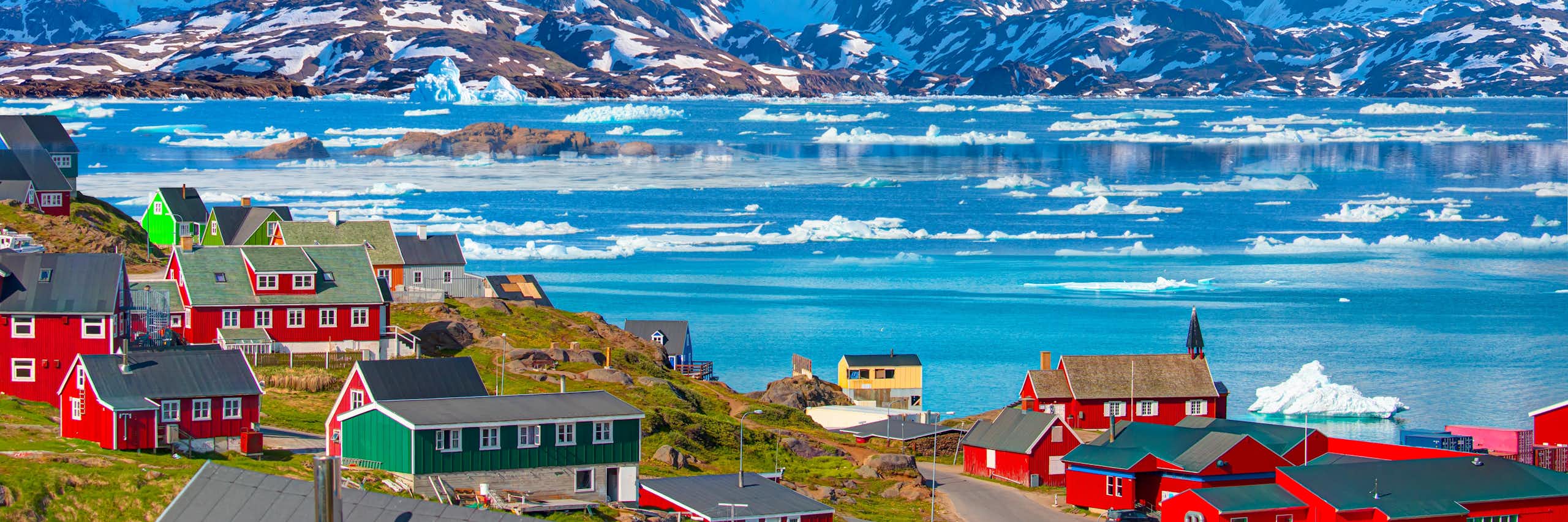 The village of Tasiilaq set against a mountainous backdrop.