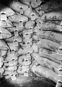 Large bags are stacked in a pile, each with a tag on it saying it came from the U.S. to help Europe.