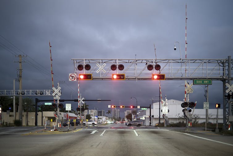 train tracks running through an intersection with multiple stoplights
