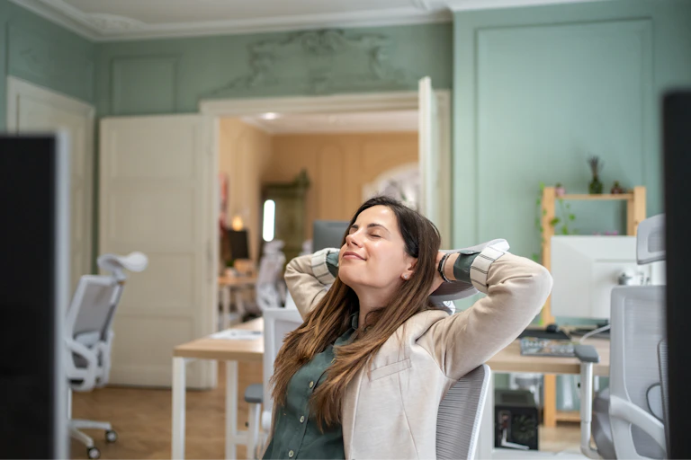 A person leans back in a chair, with a relaxed facial expression.