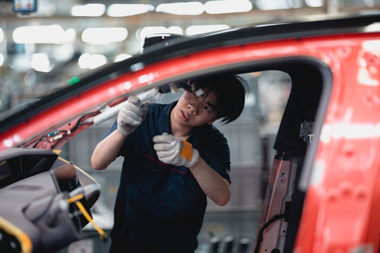 A labourer works on an assembly line at an electric vehicle factory in China