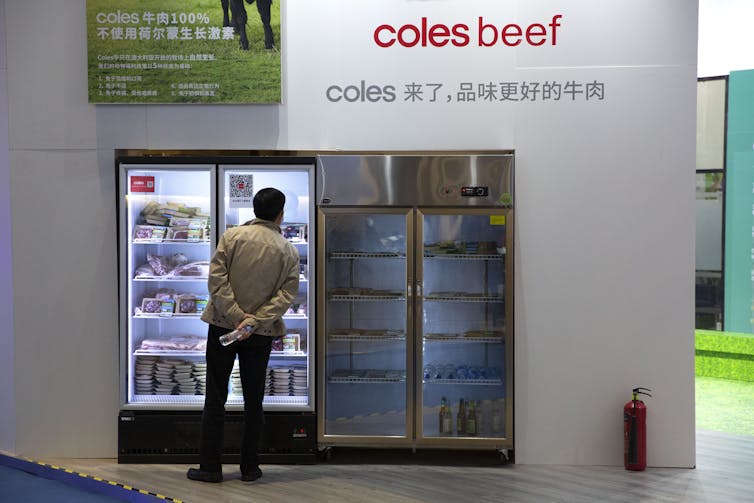 A visitor looks at a freezer displaying packaged beef from Australian retailer Coles