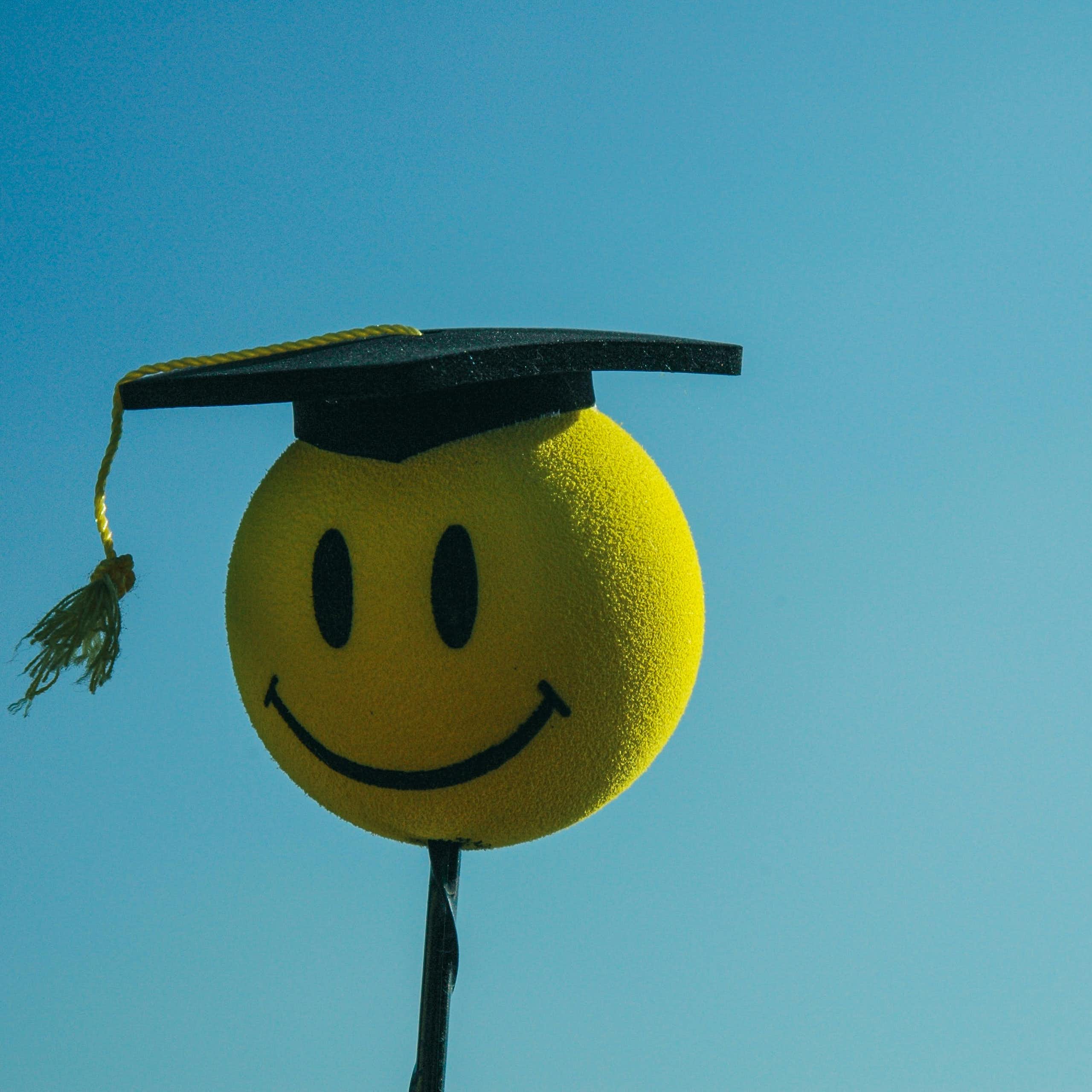 Un smiley portant un chapeau de diplômé