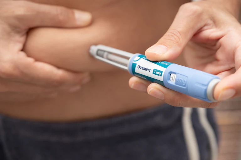 Une personne est en train de s’injecter une dose d’un médicament antiobésité dans le ventre.