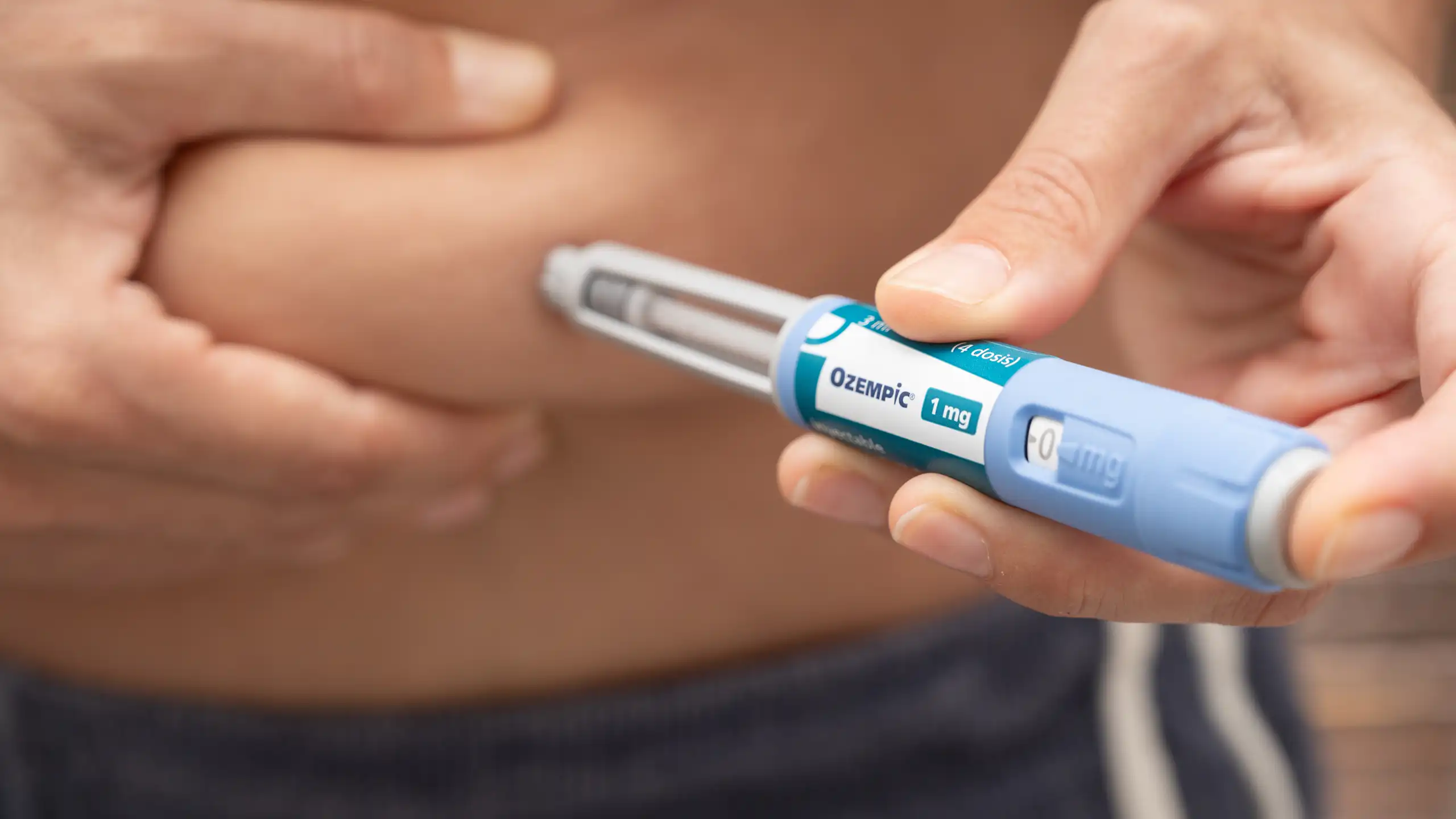 Une personne est en train de s’injecter une dose d’un médicament antiobésité dans le ventre.