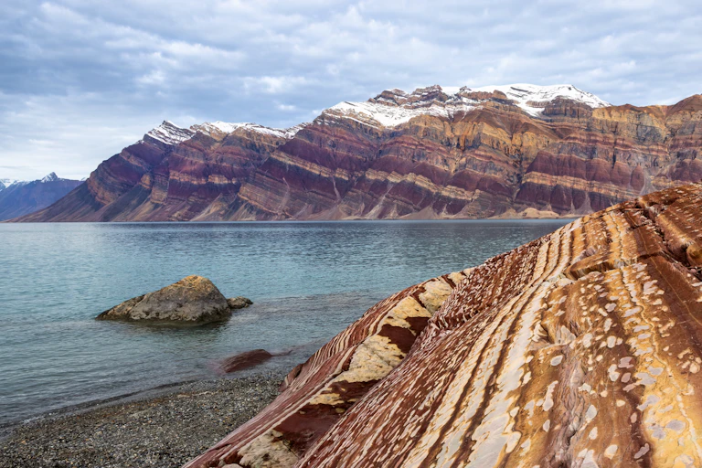 A view of colourful rock formations surrounding one of Greenland's fjords.