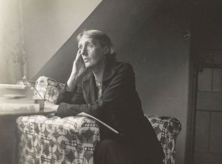 Virginia Woolf sat at a chair gazing out of a window