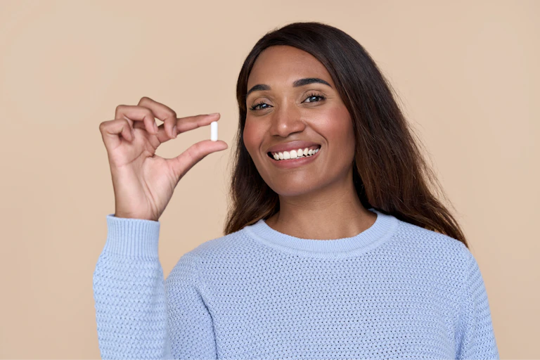 Happy looking woman holding a supplement