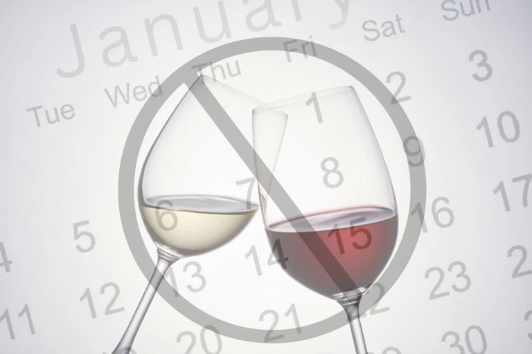 Two wine glasses in a circle with a line through it, against the backdrop of January's calendar