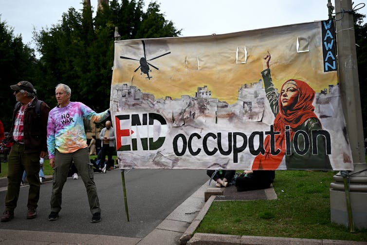 A large protest banner that says end occupation