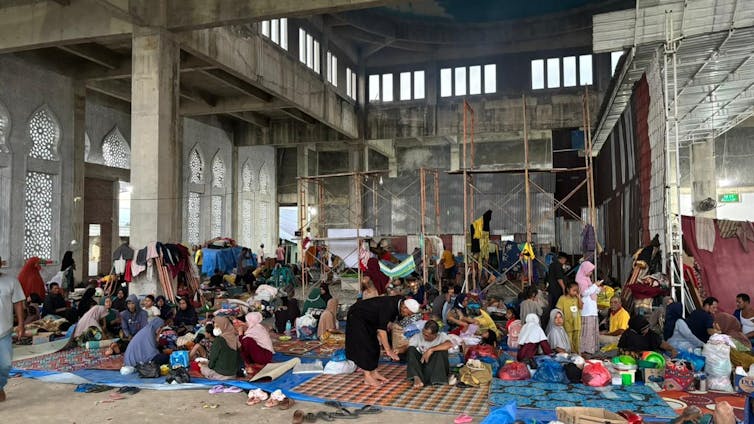 un grupo de personas sentadas en el suelo de un edificio