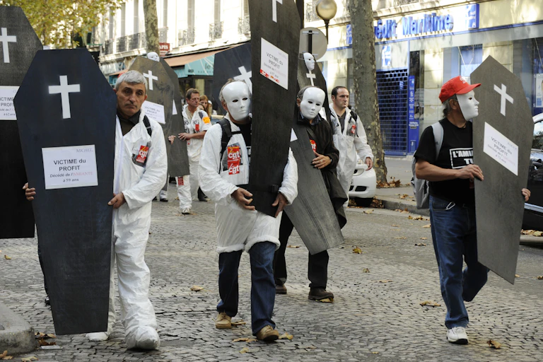 Manifestants de la CGT portants de faux cercueils où il est inscrit : « Victimes du profit. »
