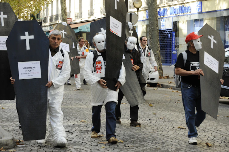 Manifestants de la CGT portants de faux cercueils où il est inscrit : « Victimes du profit. »