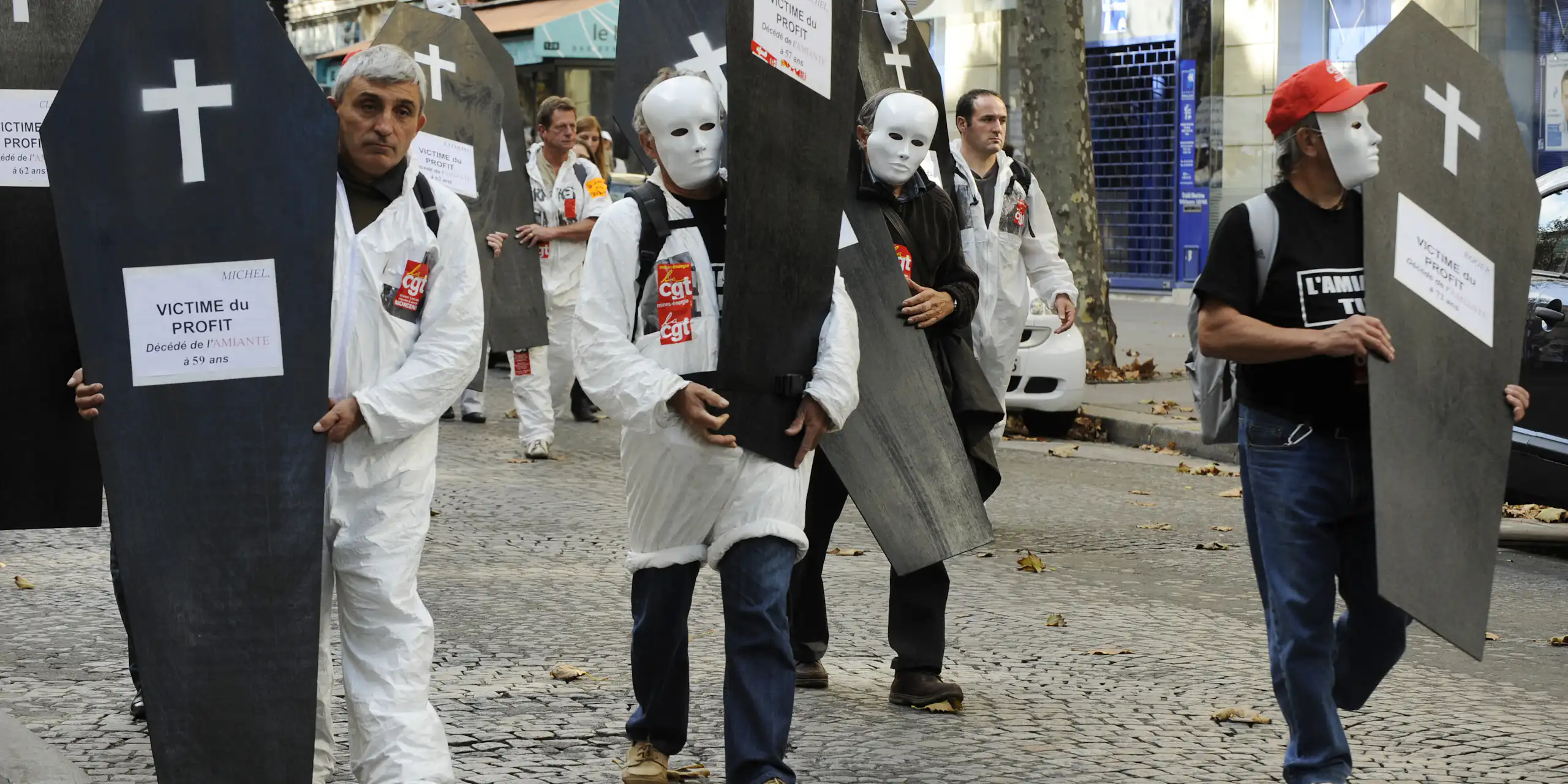 Manifestants de la CGT portants de faux cercueils où il est inscrit : « Victimes du profit. »