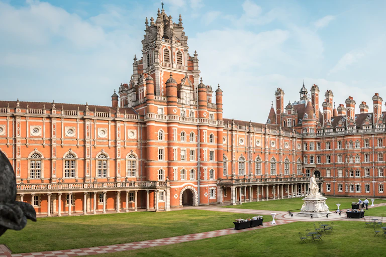A ornate Victorian university building with a central green.