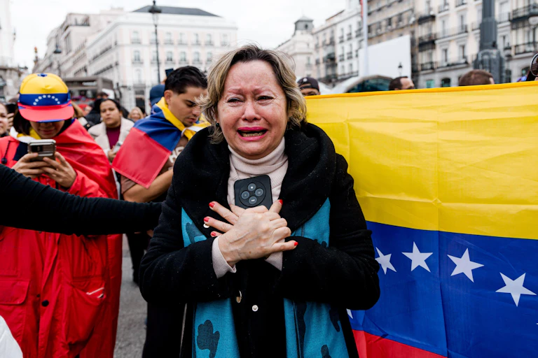 A woman crying with the Venezuelan flag in the background.