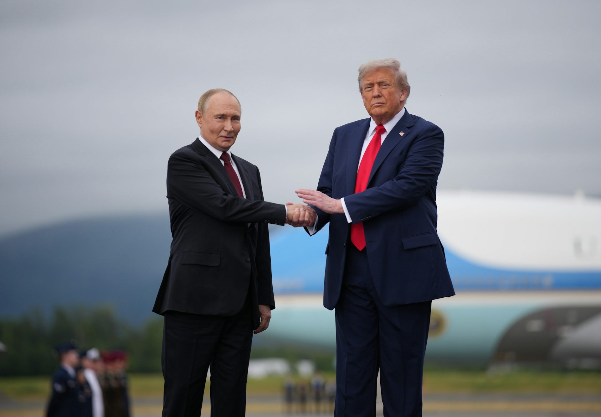 Two men in suits shake hands