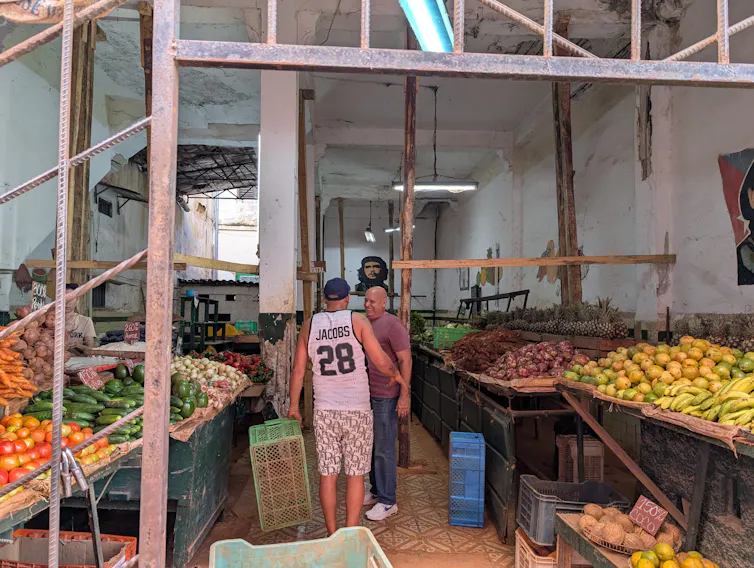 Two men greeting each other in a grocery store in Havana, Cuba.