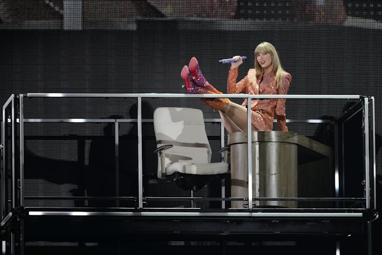 Taylor Swift swings her legs up during a concert performance.
