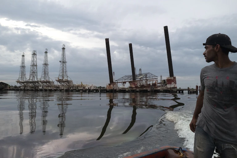 A man takes a look at some dilapidated oil infrastructure.