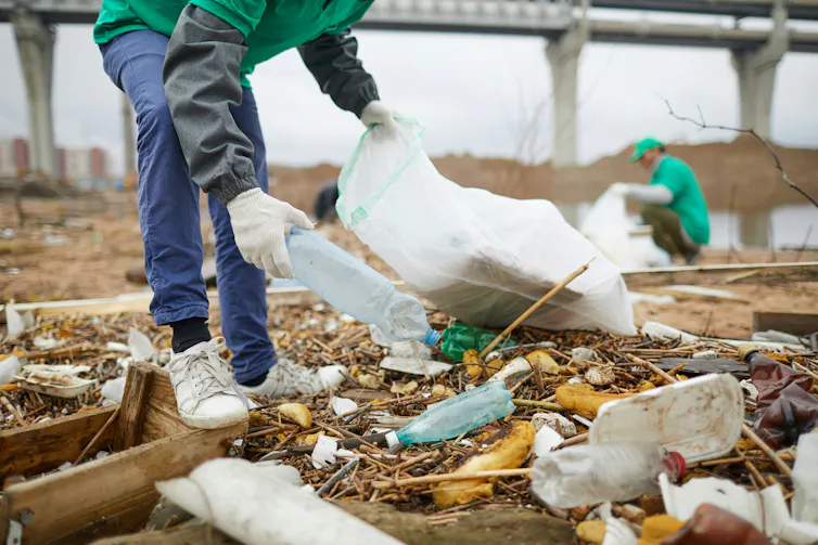 Des gens ramassent des déchets plastiques au sol