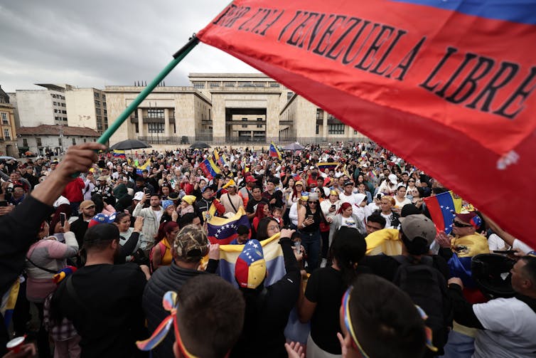 Bandera roja ondeando multitud celebrando.