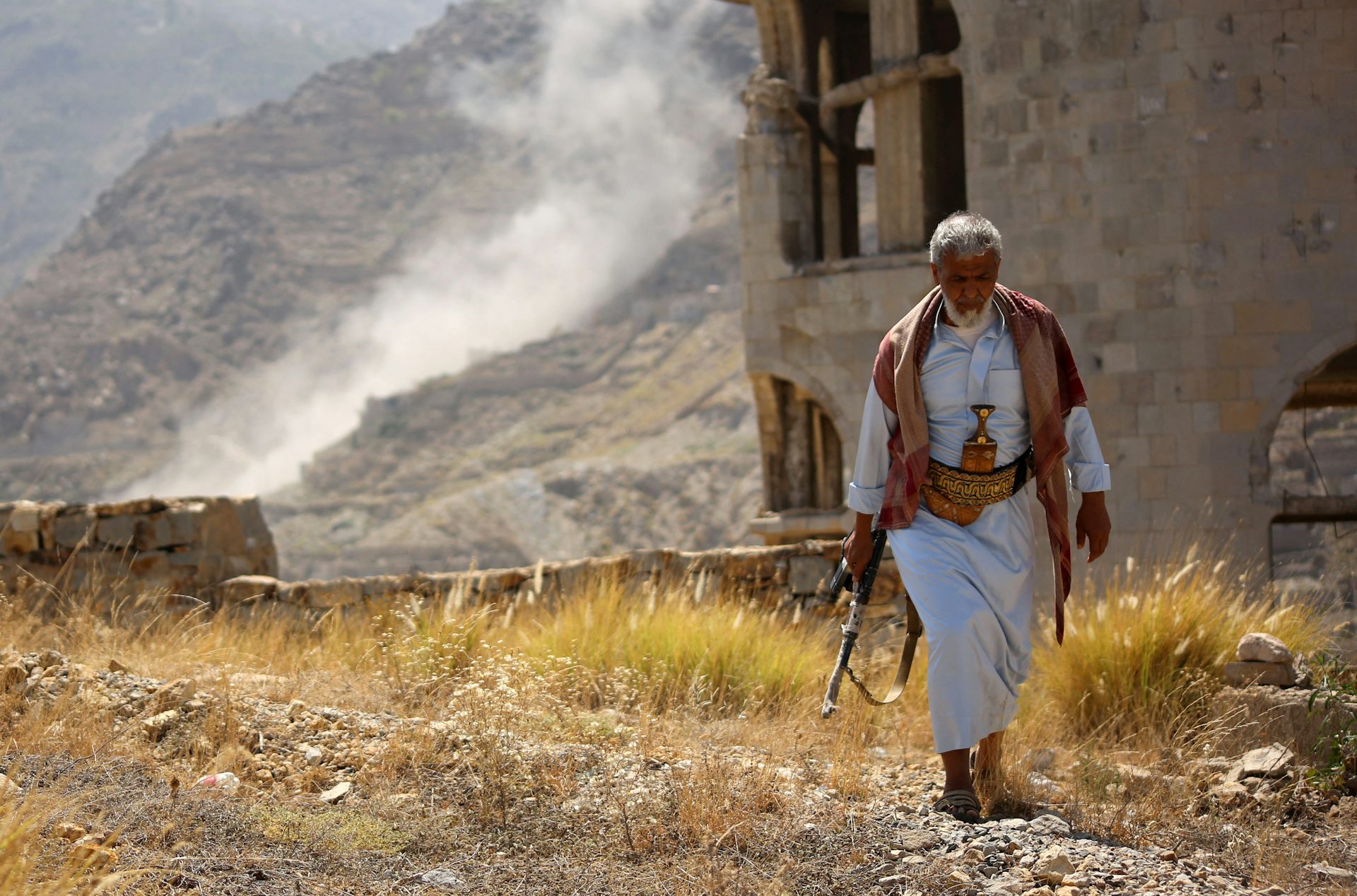 A man walks down a dust track.