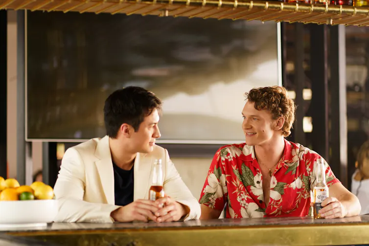 Production image: the couple have a drink.