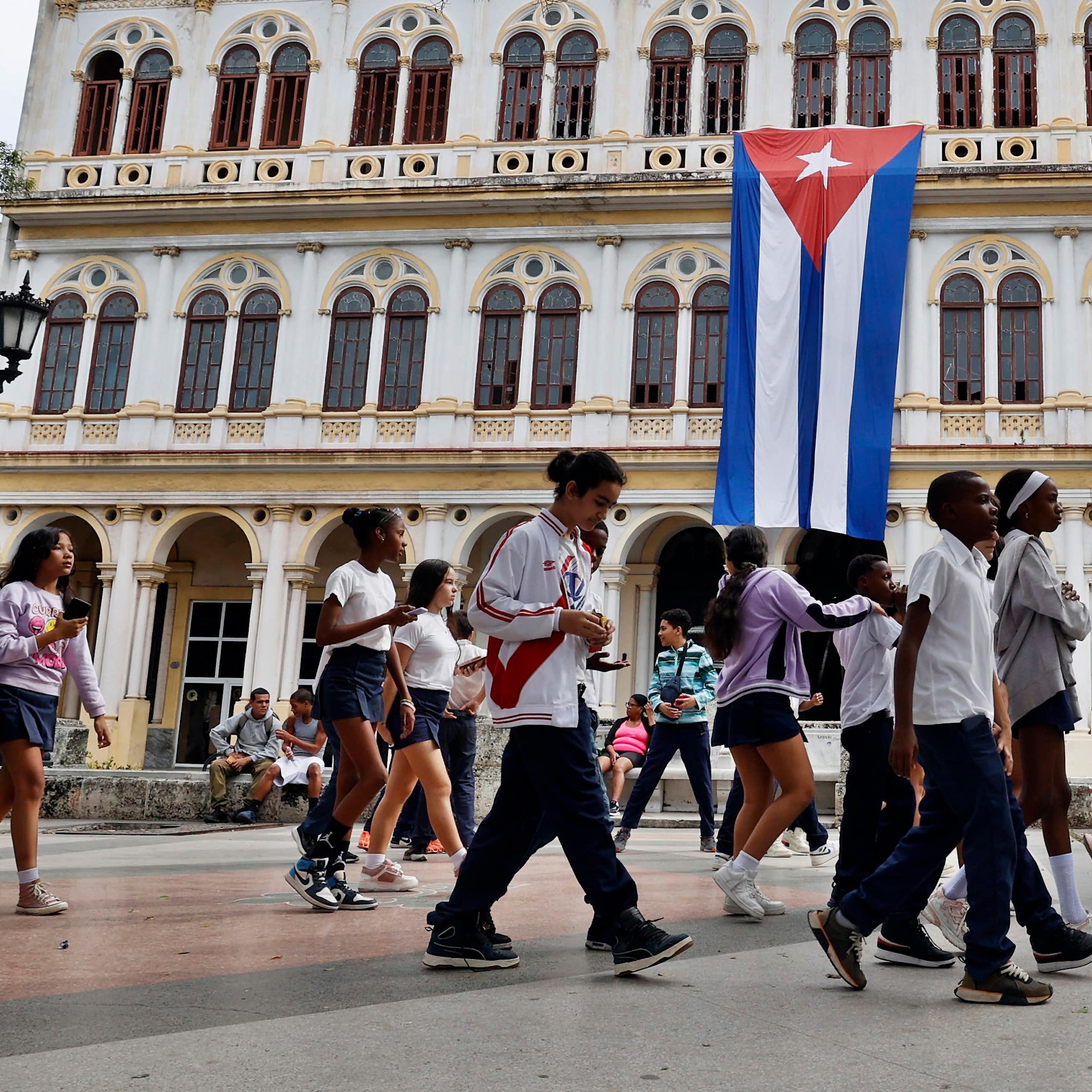 People walk through a park in Havana.