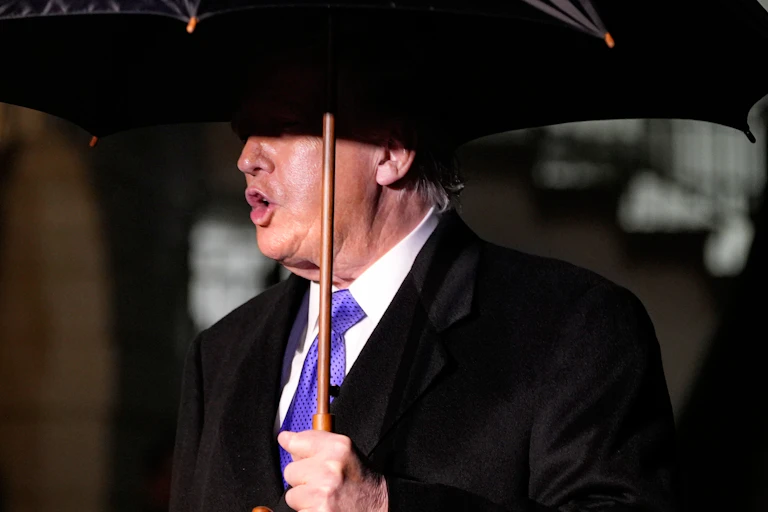 An older man under a black umbrella.