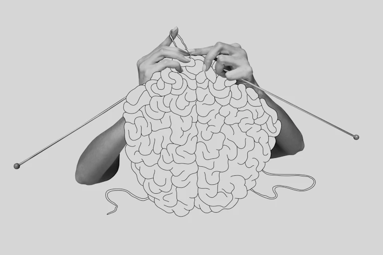 Black and white image of hands knitting a human brain