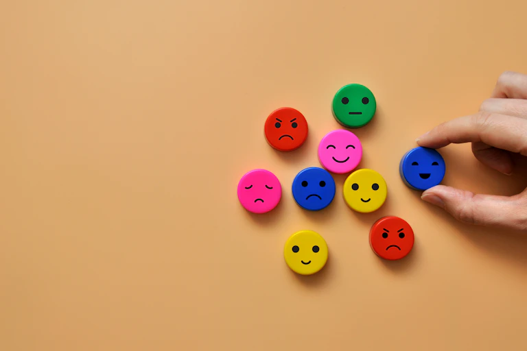 brown background, 9 colourful face discs with different expressions