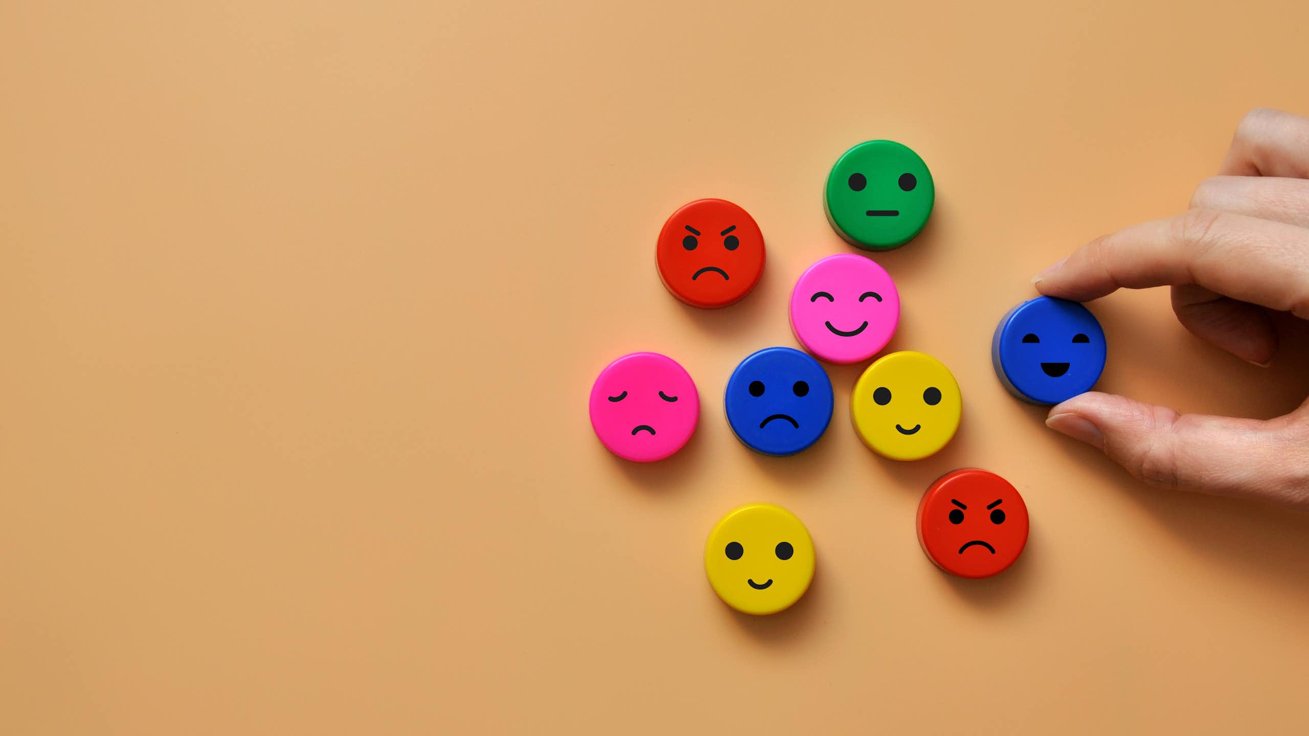 brown background, 9 colourful face discs with different expressions