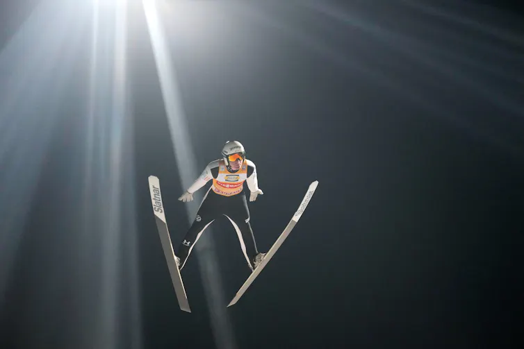 A ski jumper flying through the air.