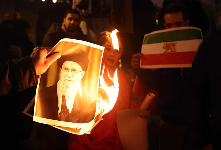 Protesters set fire to a portrait of Ayatollah Ali Khamenei.