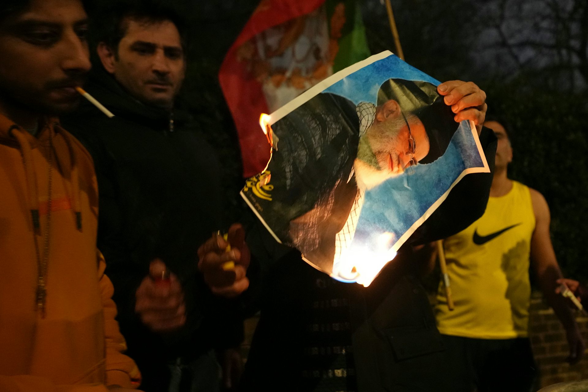 A photo of Ayatollah Ali Khomenei is set on fire by protesters