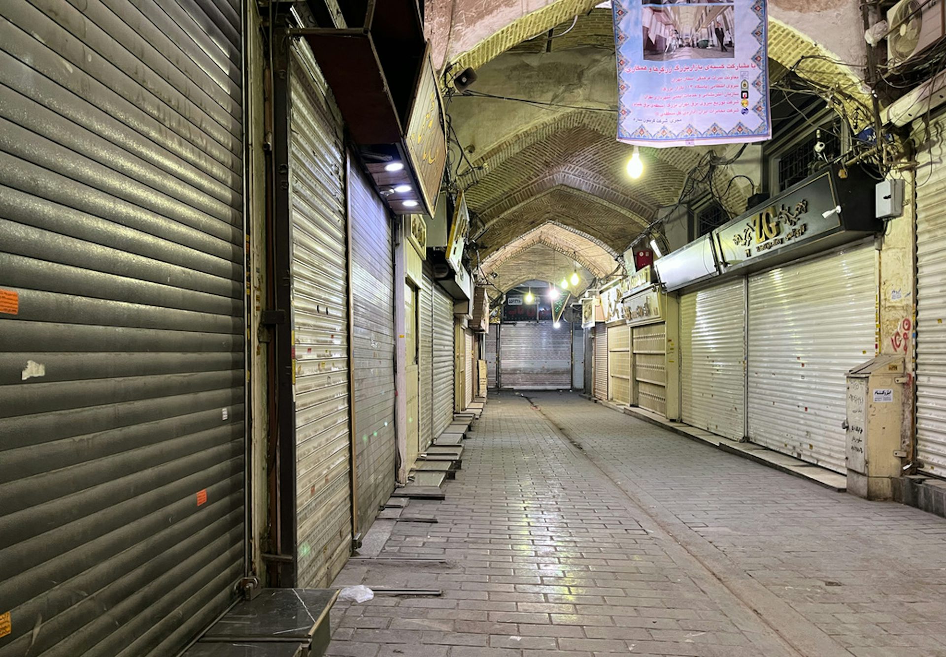An empty indoor market shown with closed shop stalls.