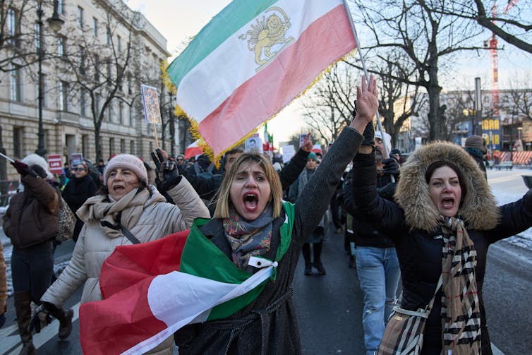 Protesters wave an Iranian flag