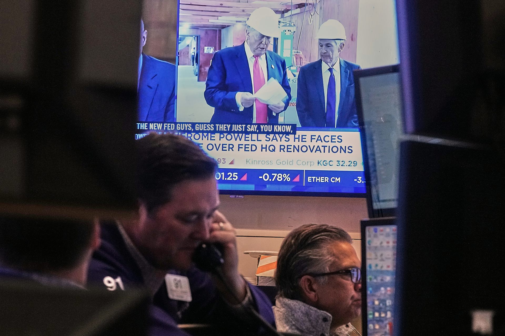 A screen shows men and a caption above other men working